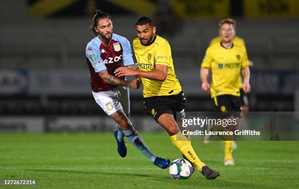 Henri Lansbury of Aston Villa battles for possession with Colin Daniel of Burton Albion during the Carabao Cup Second Round match between Burton...