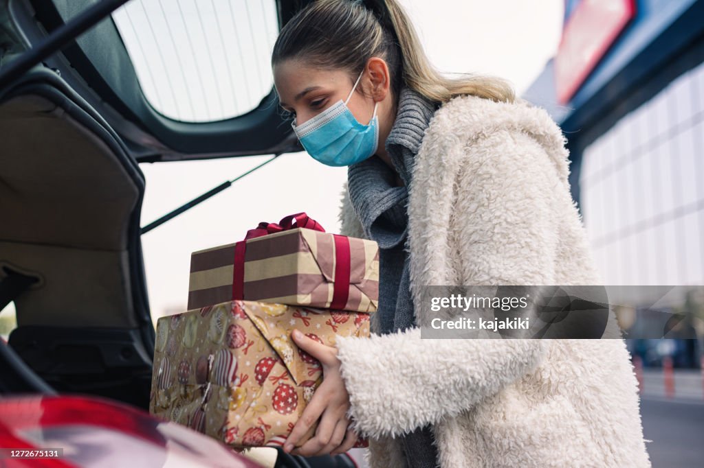 Teenage girl wears a protective mask while shopping for Christmas during COVID-19 pandemic