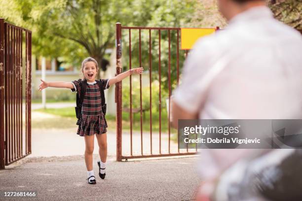upphetsad skolflicka sprider sina händer och närmar sig sin far med glädje - schoolgirl bildbanksfoton och bilder