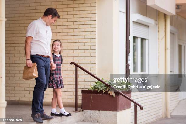 mens die van school met dochter loopt terwijl het dragen van lunchdoos - schoolgirl stockfoto's en -beelden