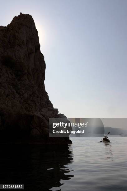 person paddling under the cliffs - high contrast stock pictures, royalty-free photos & images