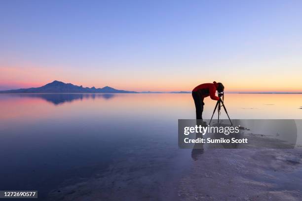 photographer taking pictures at dawn, bonneville salt flats near great salt lake, utah - lago salgado imagens e fotografias de stock