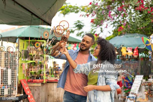 tourists buying outdoor craft - craft market stock pictures, royalty-free photos & images