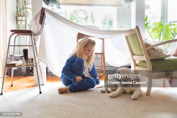 girl sits in playhouse with puppy - casa de brinquedo imagens e fotografias de stock