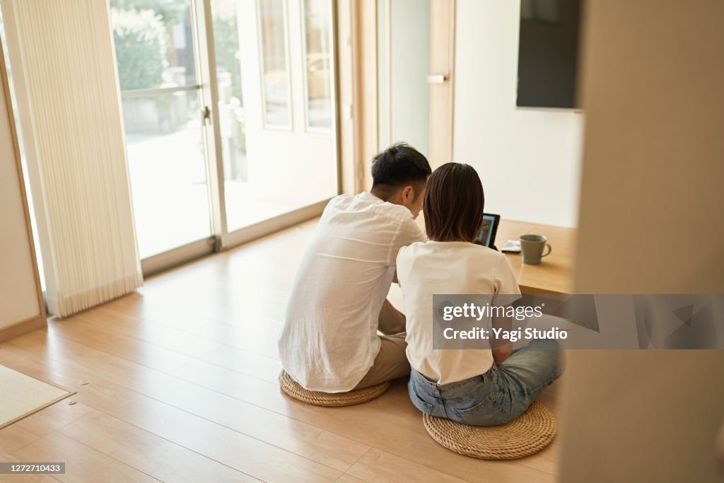 Asian Couple using a Digital Tablet in living room.