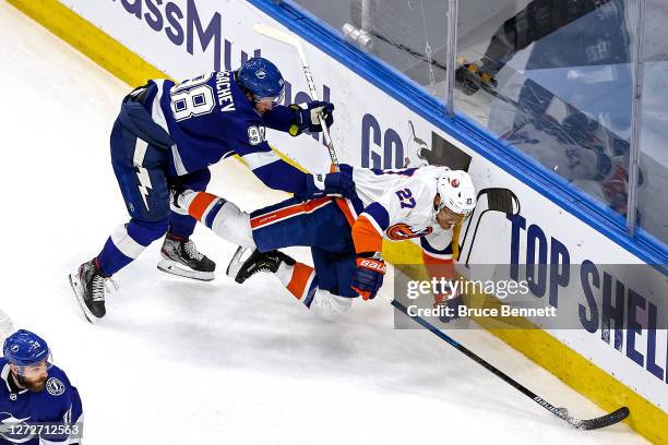 Mikhail Sergachev of the Tampa Bay Lightning checks Anders Lee of the New York Islanders into the boards during the third period in Game Five of the...
