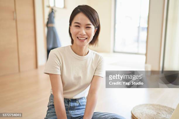 woman relaxing in the living room. - japanese woman stock pictures, royalty-free photos & images