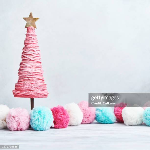 bright christmas background with pastel pompoms and pink christmas tree on white wood - pastel christmas stock pictures, royalty-free photos & images