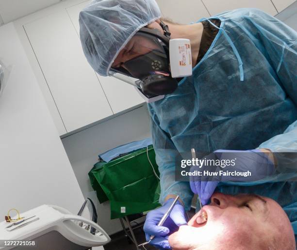 Dental Surgeon Craig Malorie wearing full surgical PPE examines the patient on August 25, 2020 in Newbridge, Wales. Unlike in England, many dental...