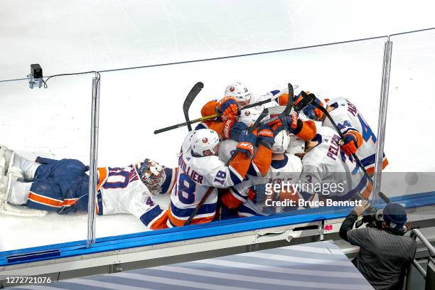 Jordan Eberle of the New York Islanders is congratulated by his teammates as Semyon Varlamov dives toward the team after scoring the game-winning...