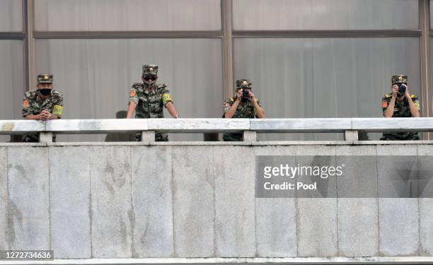 North Korean army soldiers wearing masks look at the South side during South Korean Unification Minister Lee In-young's visit to Panmunjom between...