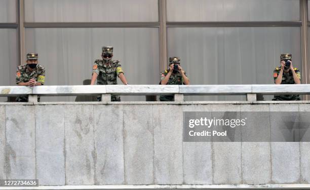 North Korean army soldiers wearing masks look at the South side during South Korean Unification Minister Lee In-young's visit to Panmunjom between...