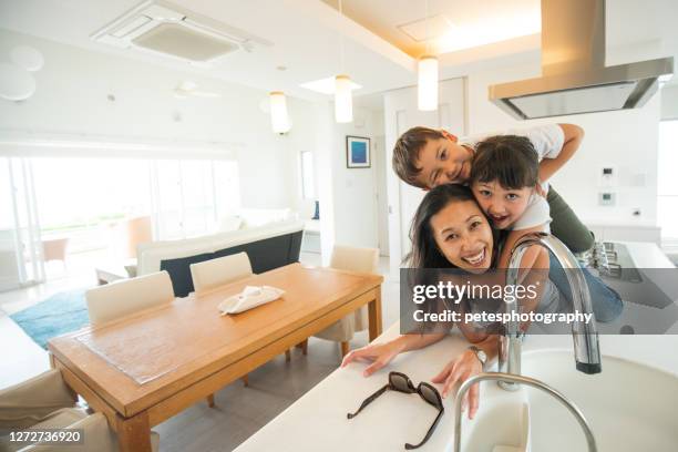 glückliche mutter und kinder auf der küchenbank - familie hell weiss stock-fotos und bilder