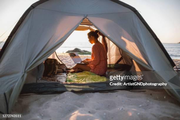 woman working with laptop on the beach. - development camp stock pictures, royalty-free photos & images
