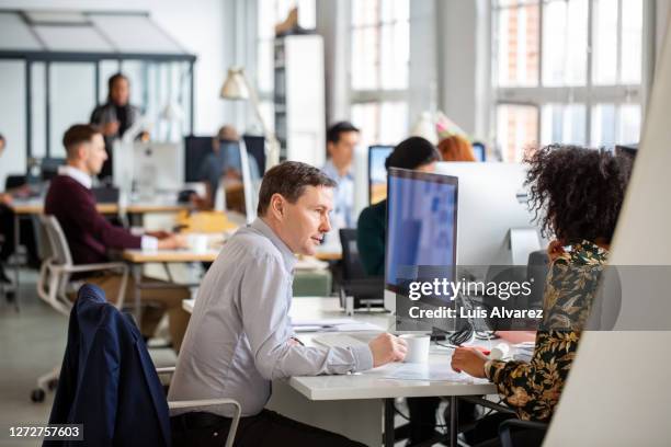 businessman discussing project details with a colleague - busy office stock pictures, royalty-free photos & images