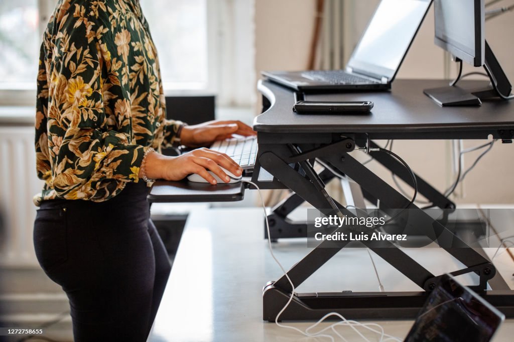 Woman working at a standing desk in office