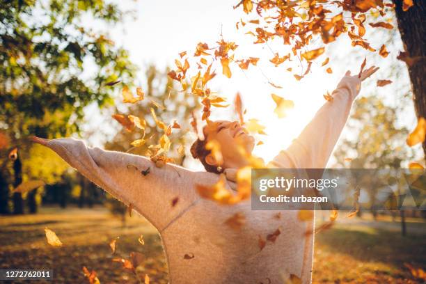 mujer feliz en el parque de otoño - otoño fotografías e imágenes de stock