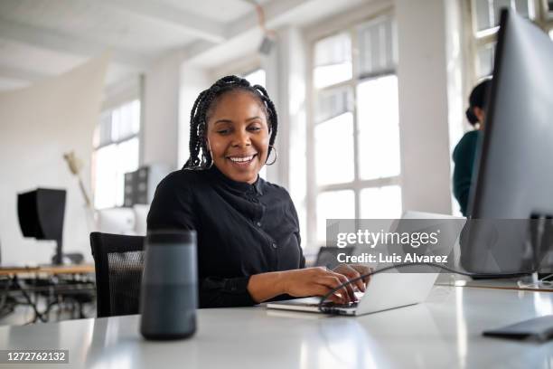 woman using virtual assistant on office desk - speech recognition stock pictures, royalty-free photos & images