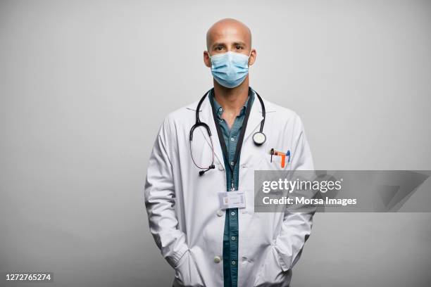 bald doctor in face mask on white background - quarantaine stock pictures, royalty-free photos & images