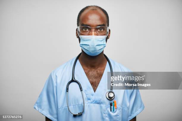 african american male doctor/nurse with stethoscope on white background - protective face mask bildbanksfoton och bilder