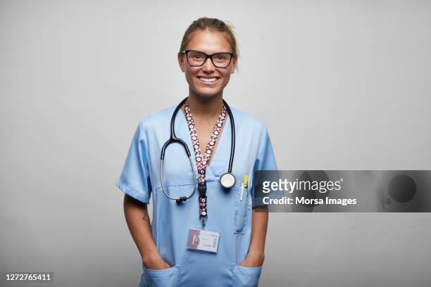 smiling nurse with stethoscope on white background - nurse and portrait and white background and smiling and female and looking at camera stock-fotos und bilder