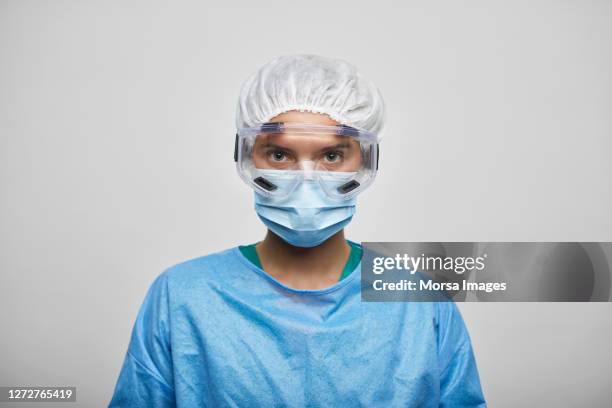 female doctor/nurse wearing coveralls on white background - face mask protective workwear imagens e fotografias de stock