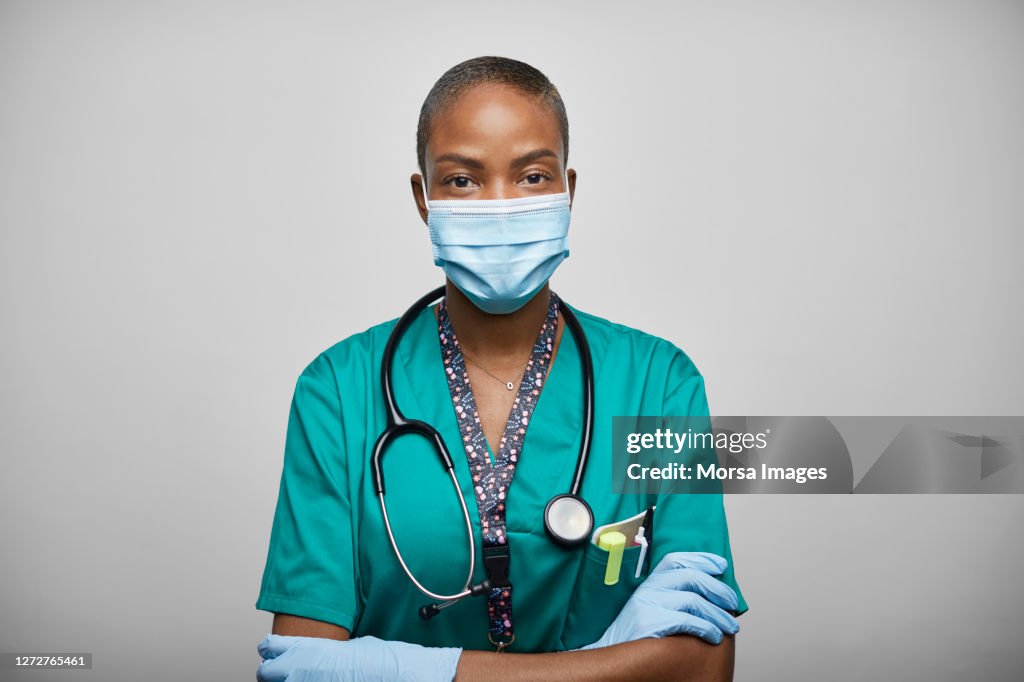 African American Doctor/Nurse With Arms Crossed Against White Background
