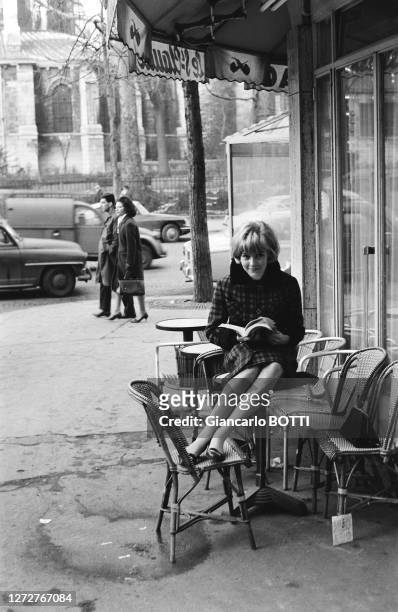 Portrait de Sylvie Vartan lisant à la terrasse d'un café du quartier latin, dans les années 1960.