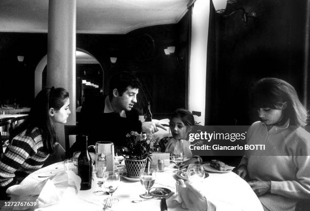 Jean-Paul Belmondo à table lors de vacances à la montagne avec sa femme Elodie et leurs filles Patricia et Florence, en 1966.