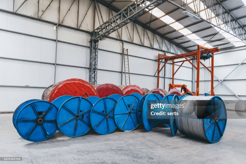 Large coils with cable wire in factory warehouse