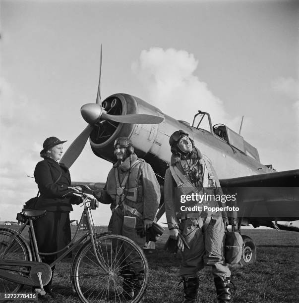 Member of the Women's Royal Naval Service , known as the Wrens, with a bicycle hands a message to the pilot of a Royal Navy Fleet Air Arm Blackburn...