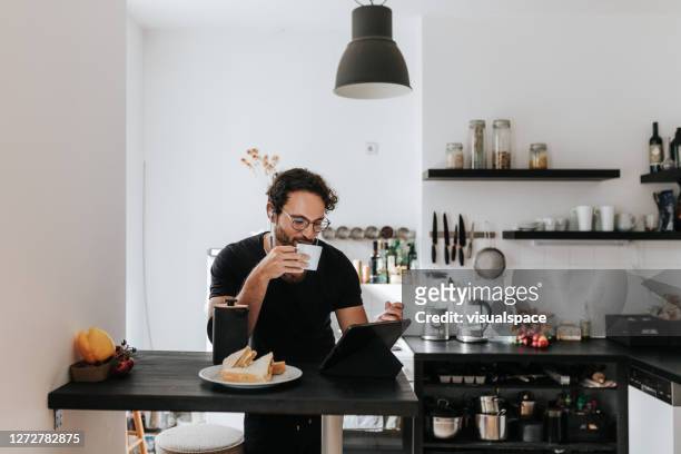 morning coffee with digital tablet - man glasses tablet in kitchen stock pictures, royalty-free photos & images