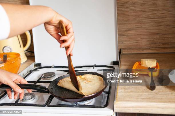woman frying blini in home kitchen - crêpe pancake 個照片及圖片檔