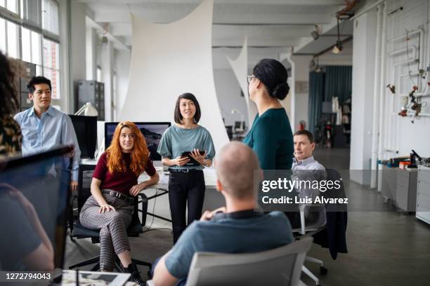 female sharing her ideas in a staff meeting - leadership listening stock-fotos und bilder