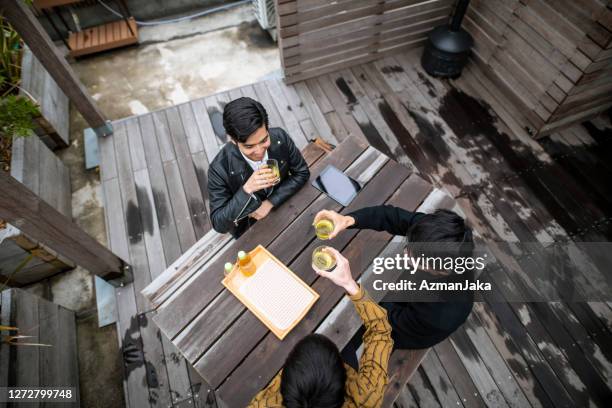 japanese men in early 20s enjoying tea on outdoor deck - top of head stock pictures, royalty-free photos & images