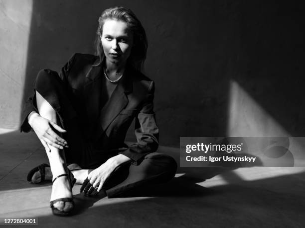 young elegant woman sitting on floor - high heel stockfoto's en -beelden