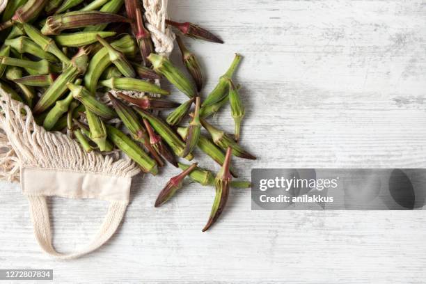 fresh organic okra on white wooden table - okra stock pictures, royalty-free photos & images