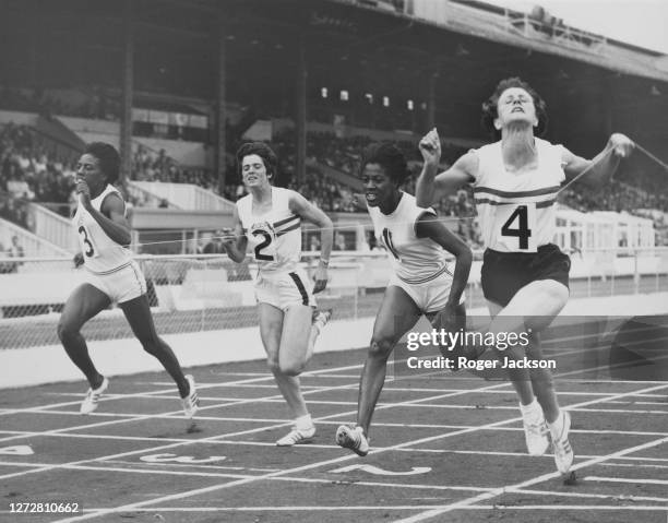 British runner Dorothy Hyman crosses the line in first place from American runner Edith McGuire , American runner Wyomia Tyus , and British runner...