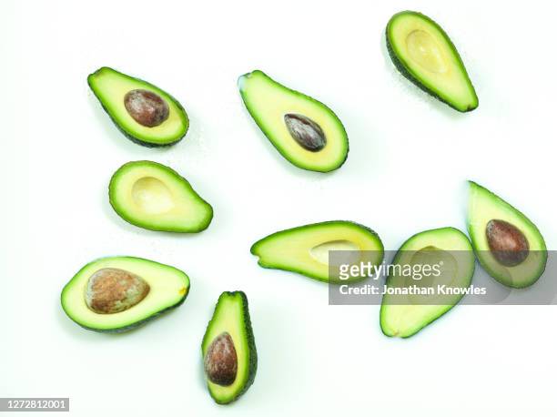 green avocado halves in milk - avocado smoothie stock-fotos und bilder