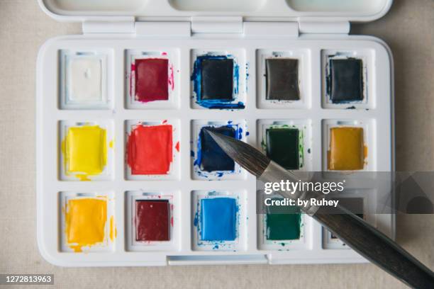 palette with multi color paints and brush on white background, top view - multi tool stock-fotos und bilder