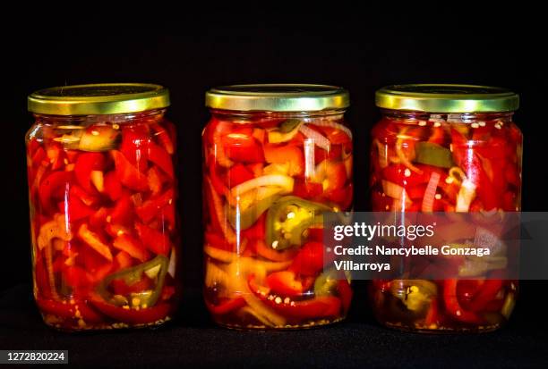 three jars of pickled red sweet peppers and hot peppers - canning stock pictures, royalty-free photos & images