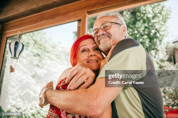 senior hispanic couple embracing at home .they are happy - couple de vieux drole photos et images de collection