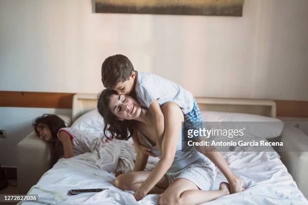 mother playing at home bedroom with her son. real life scene - young tiny girls stock pictures, royalty-free photos & images