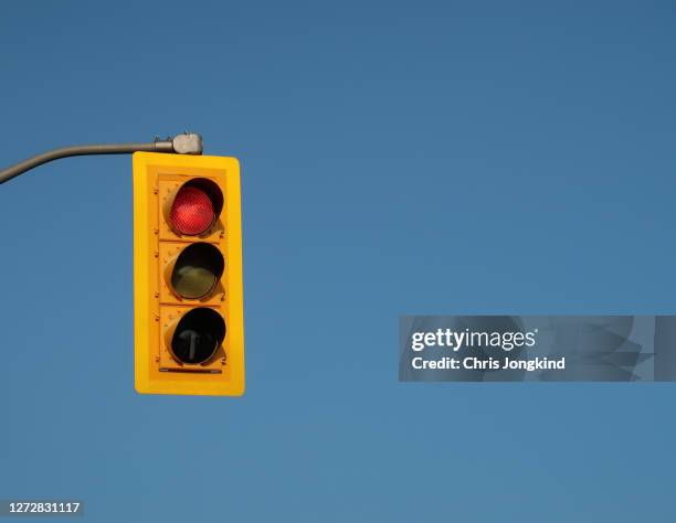 red traffic light against blue sky - semaforo rosso foto e immagini stock