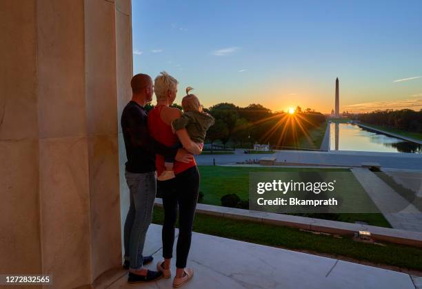 föräldrar och deras småbarn dotter vid lincoln memorial med washington memorial i bakgrunden vid sunrise i washington dc huvudstad i usa - washingtonmonumentet dc bildbanksfoton och bilder