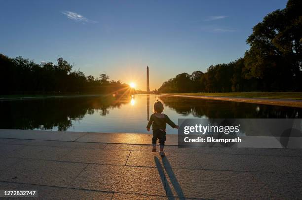 coppia con un bambino al lincoln memorial con il washington memorial sullo sfondo all'alba a washington dc capitale degli stati uniti - the mall foto e immagini stock