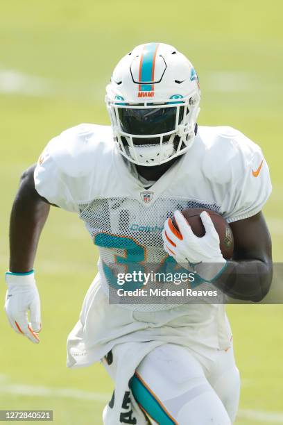 Jordan Howard of the Miami Dolphins runs with the ball during a drill at practice at Baptist Health Training Facility at Nova Southern University on...