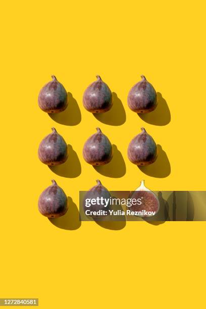 repeated figs and one halved fig on the yellow background - fig stock pictures, royalty-free photos & images