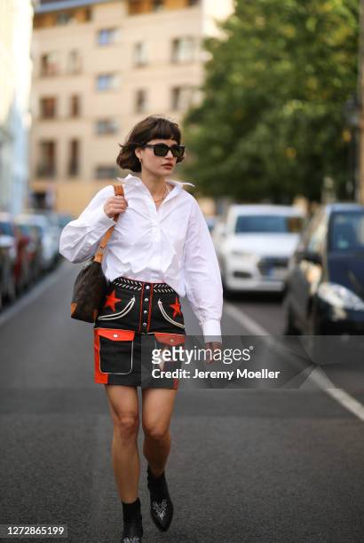 Lea Neumann wearing white shirt, leather vintage skirt, Louis Vuitton bag, Messy Weekend shades and black boots on September 12, 2020 in Berlin,...