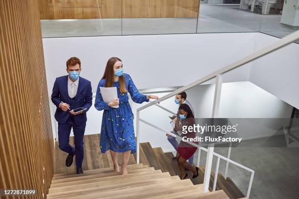 business coworkers returning to work wearing face masks after a lockdown during coronavirus epidemic - arrival stock pictures, royalty-free photos & images